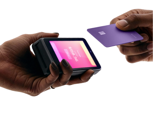 Hands holding the Helcim Card Reader and a credit card