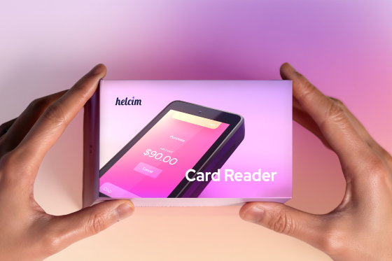 Hands holding the Helcim Card Reader packaging