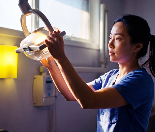 Healthcare professional adjusting an exam light in a modern clinic