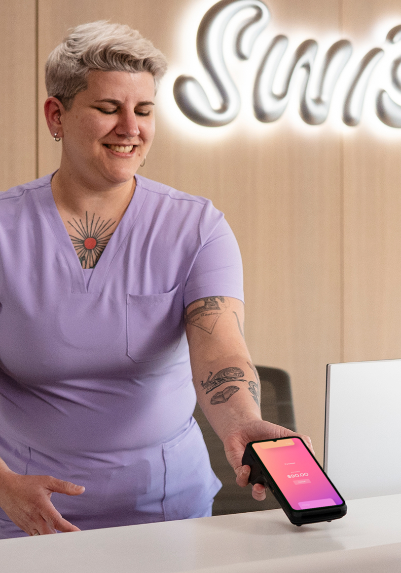 Pharmacist reviewing orders with Helcim terminal nearby