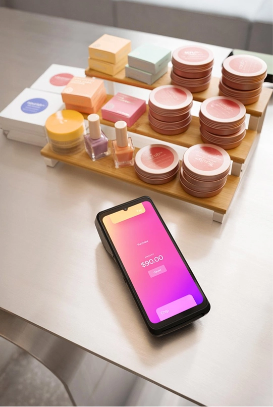 Merchant holding Helcim Smart Terminal while customer inserts card