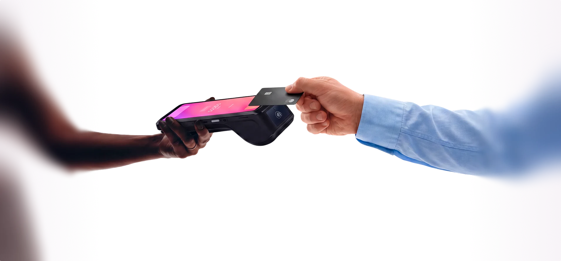 Two hands exchanging a card payment on a Helcim card reader