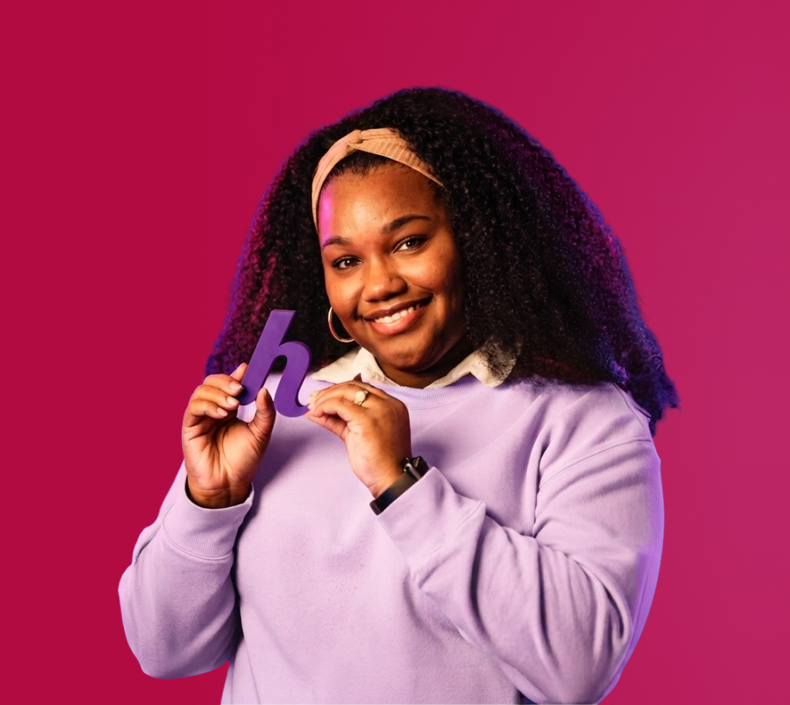 A friendly Helcim team member holding a purple Helcim logo