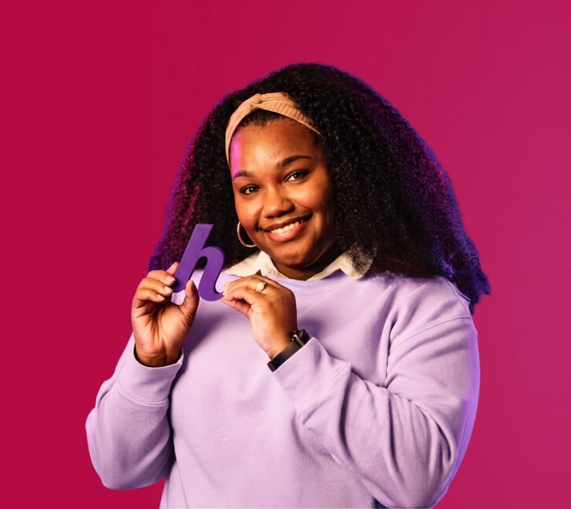 A friendly Helcim team member holding a purple Helcim logo