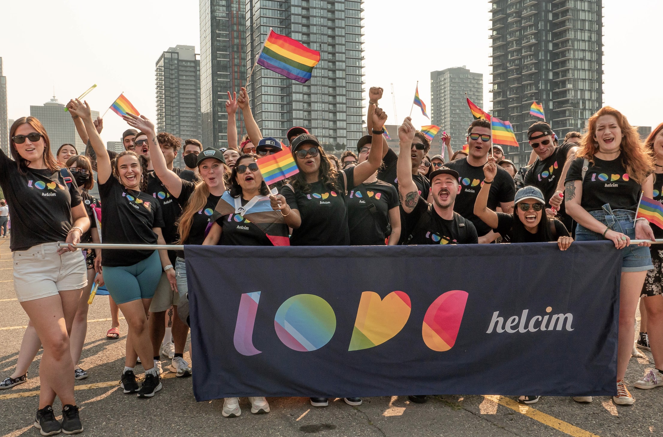 Helcim team members at 2022 Pride Parade posing for a photo with Helcim "love" Banner