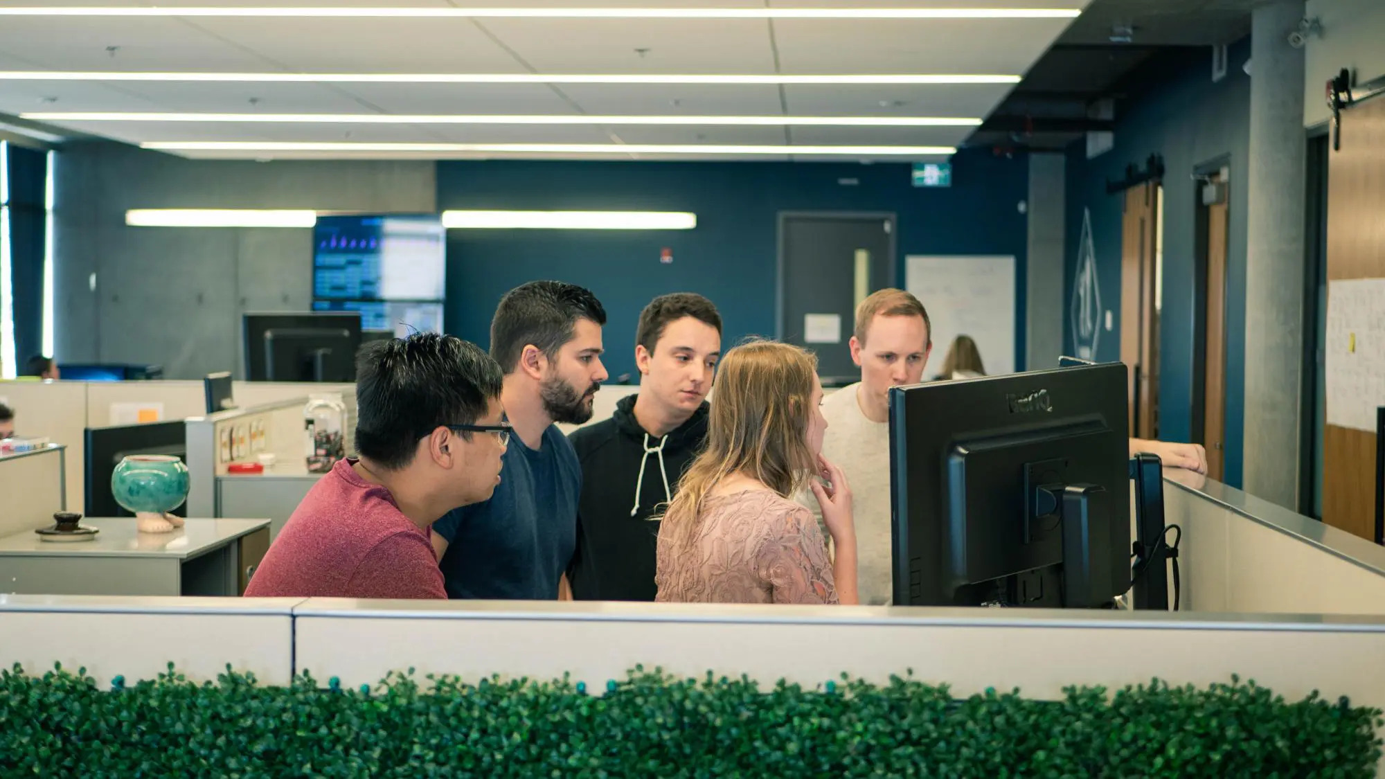 Helcim team gathered around a computer screen