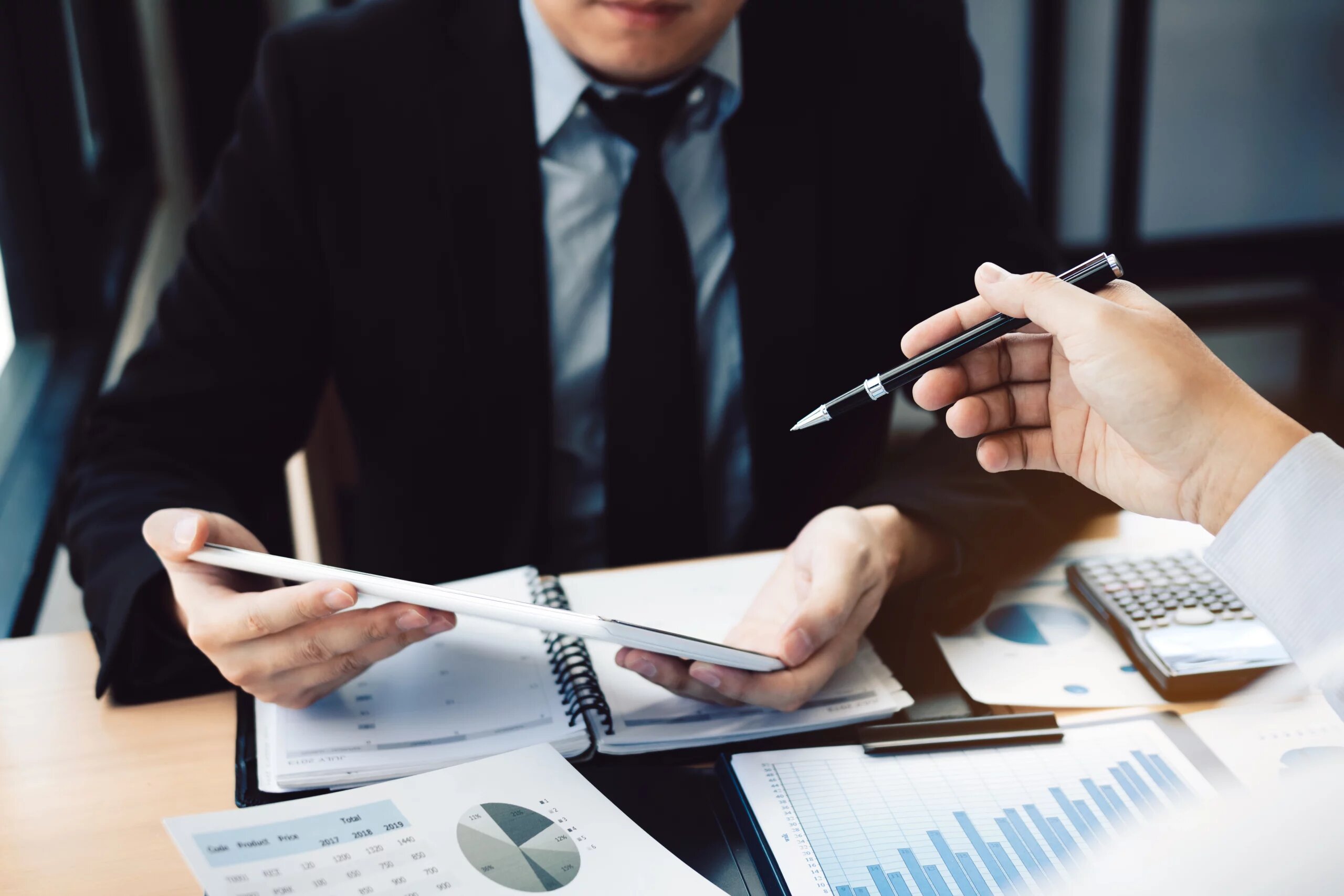 Business person analyzing and signing papers