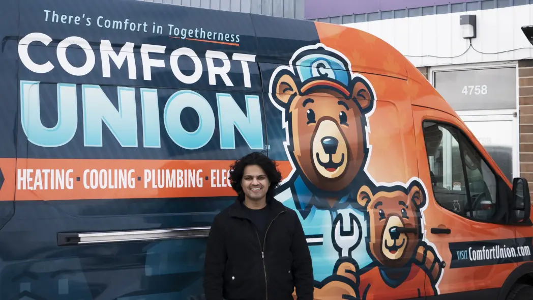 Asif, the owner of Comfort Union, standing in front of his service van