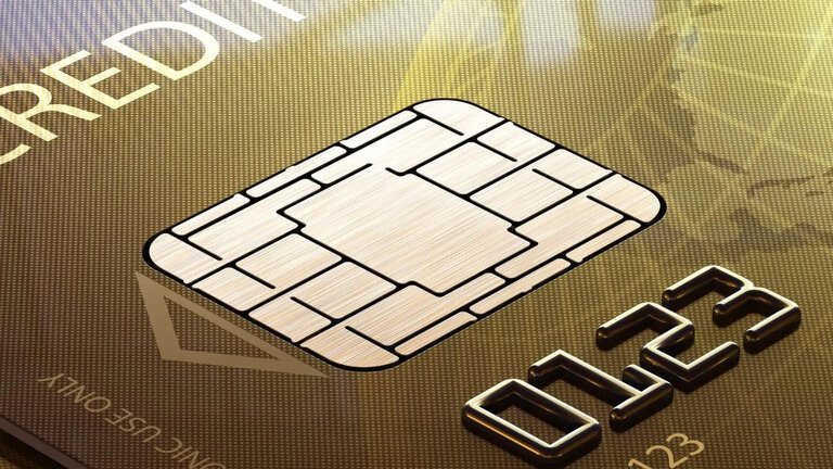 A gold credit card with a close up on the chip