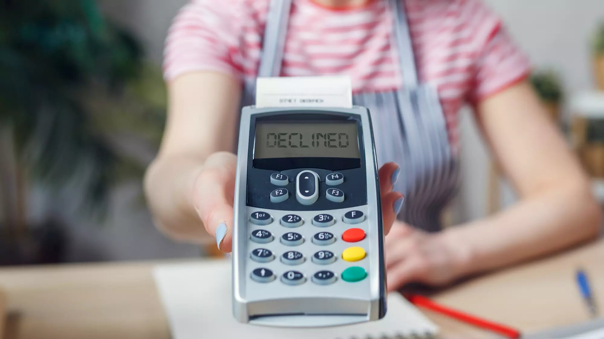 A person presenting a card reader that says declined on the screen