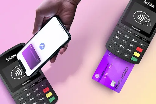 Image of a hand using a phone to make a payment to a card reader with another card reader with a chip inserted