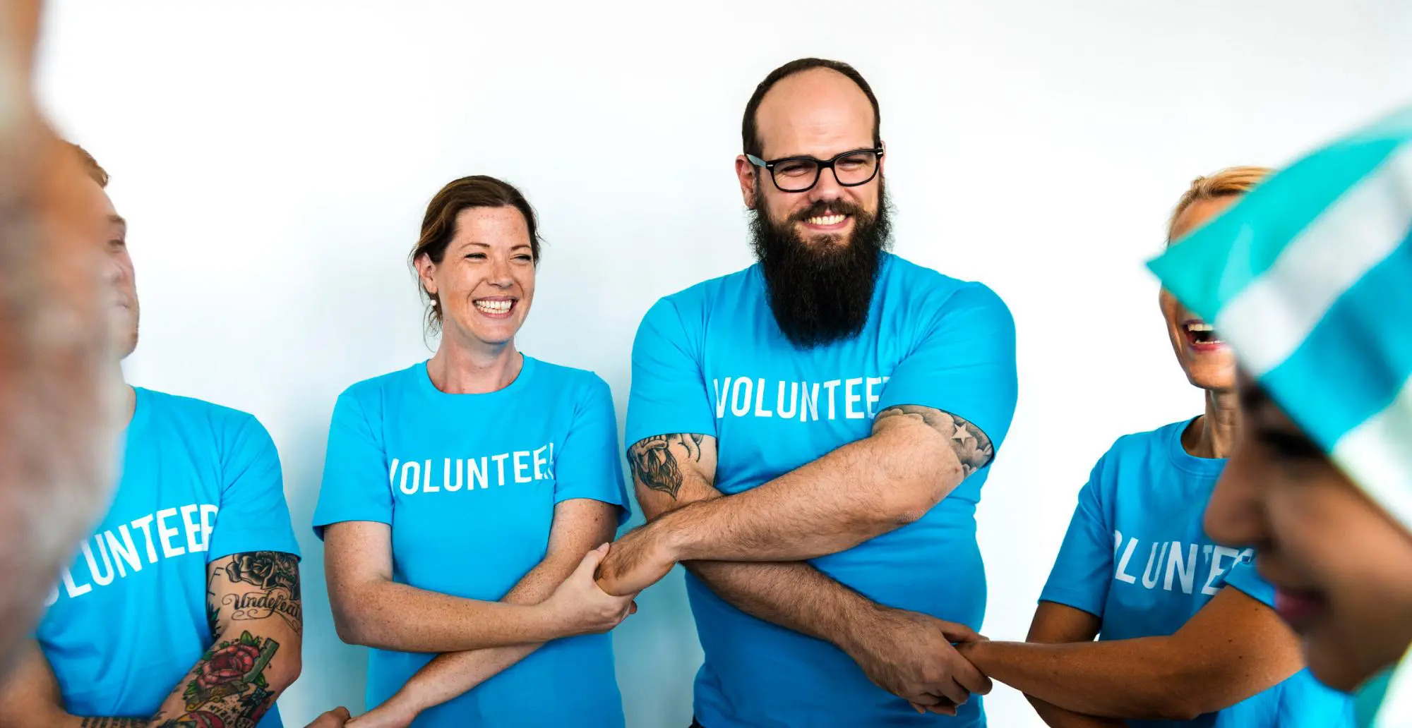 Volunteers crossing arms and holding hands for Non Profit Credit Card Processing
