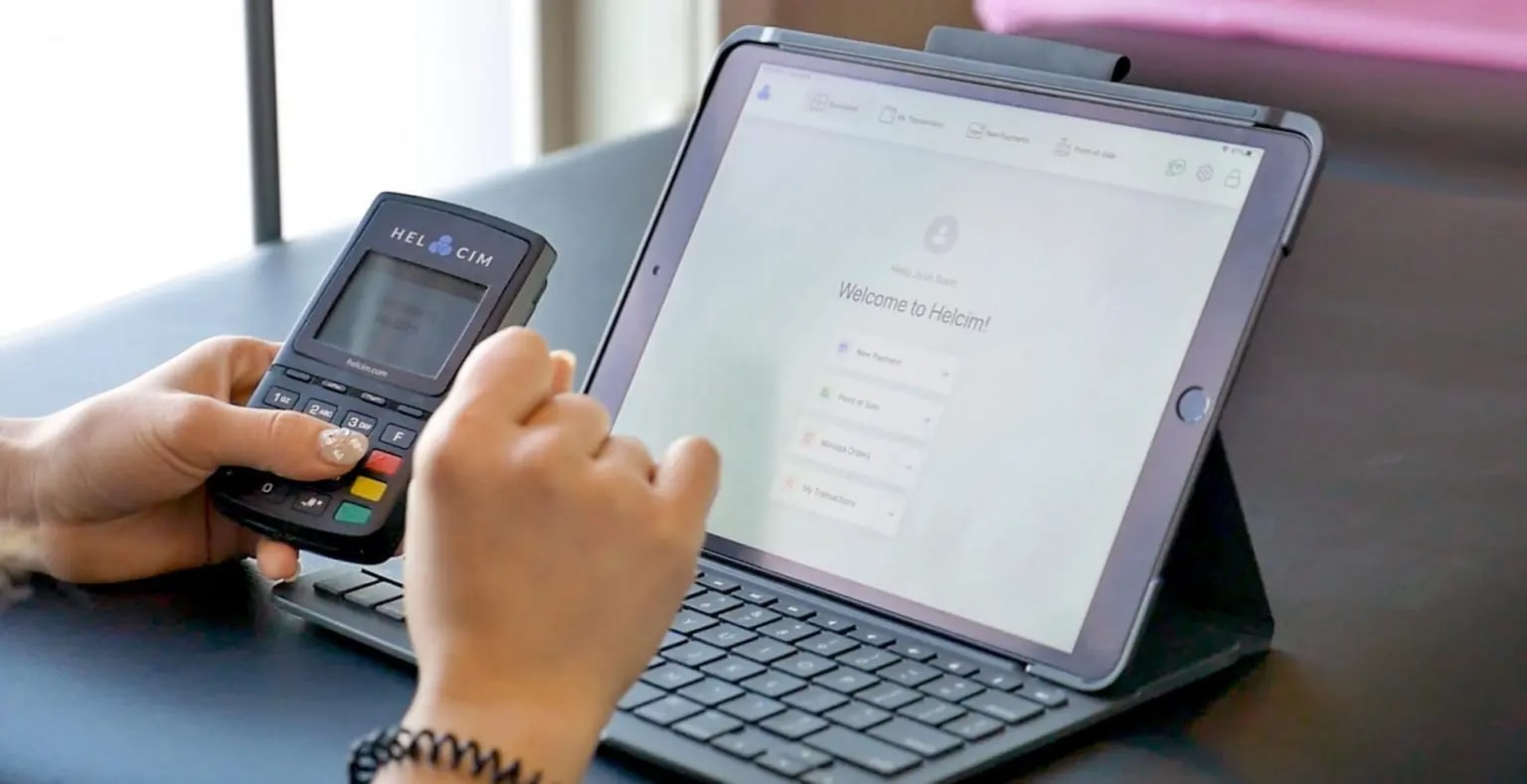 Helcim card reader and the Helcim payment platform on a laptop