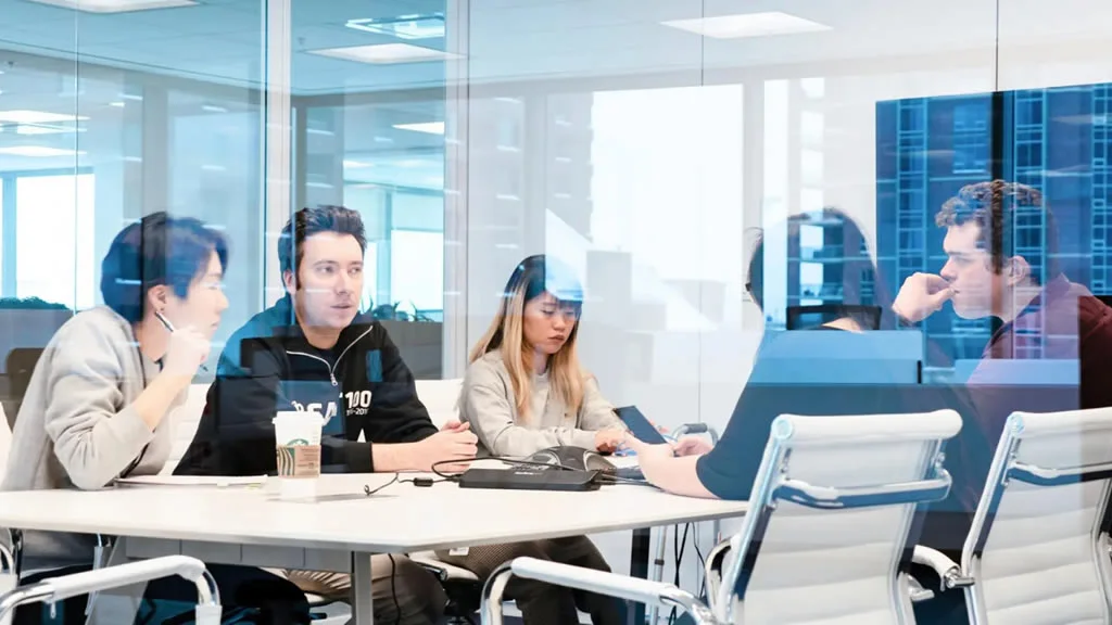 Helcim employees in a boardroom brainstorming how to create a better user experience