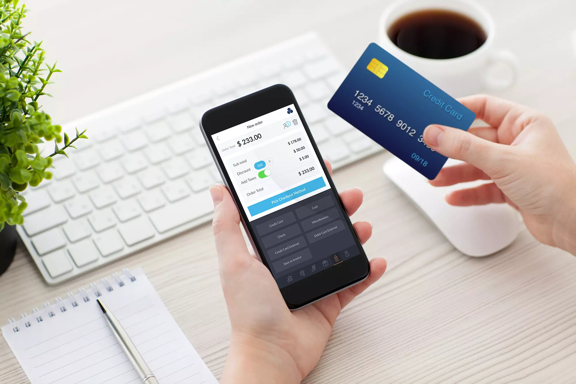 a mobile device showing all credit card payment options available and a hand holding a credit card