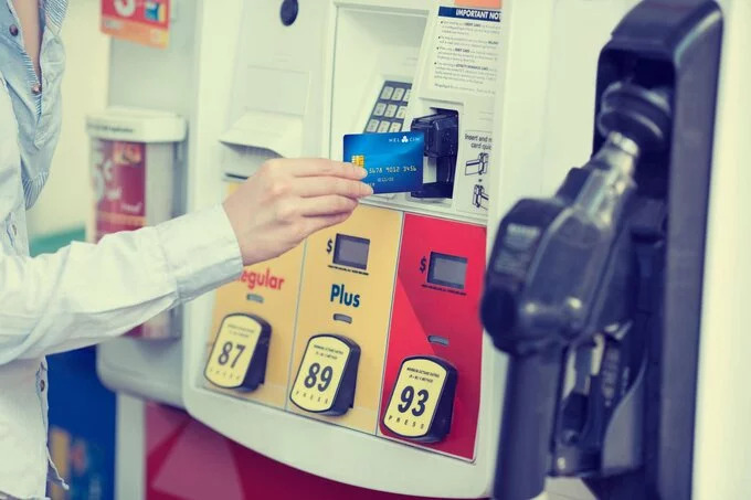 A person paying for gas at the pump with a credit card