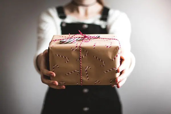woman presenting a wrapped gift