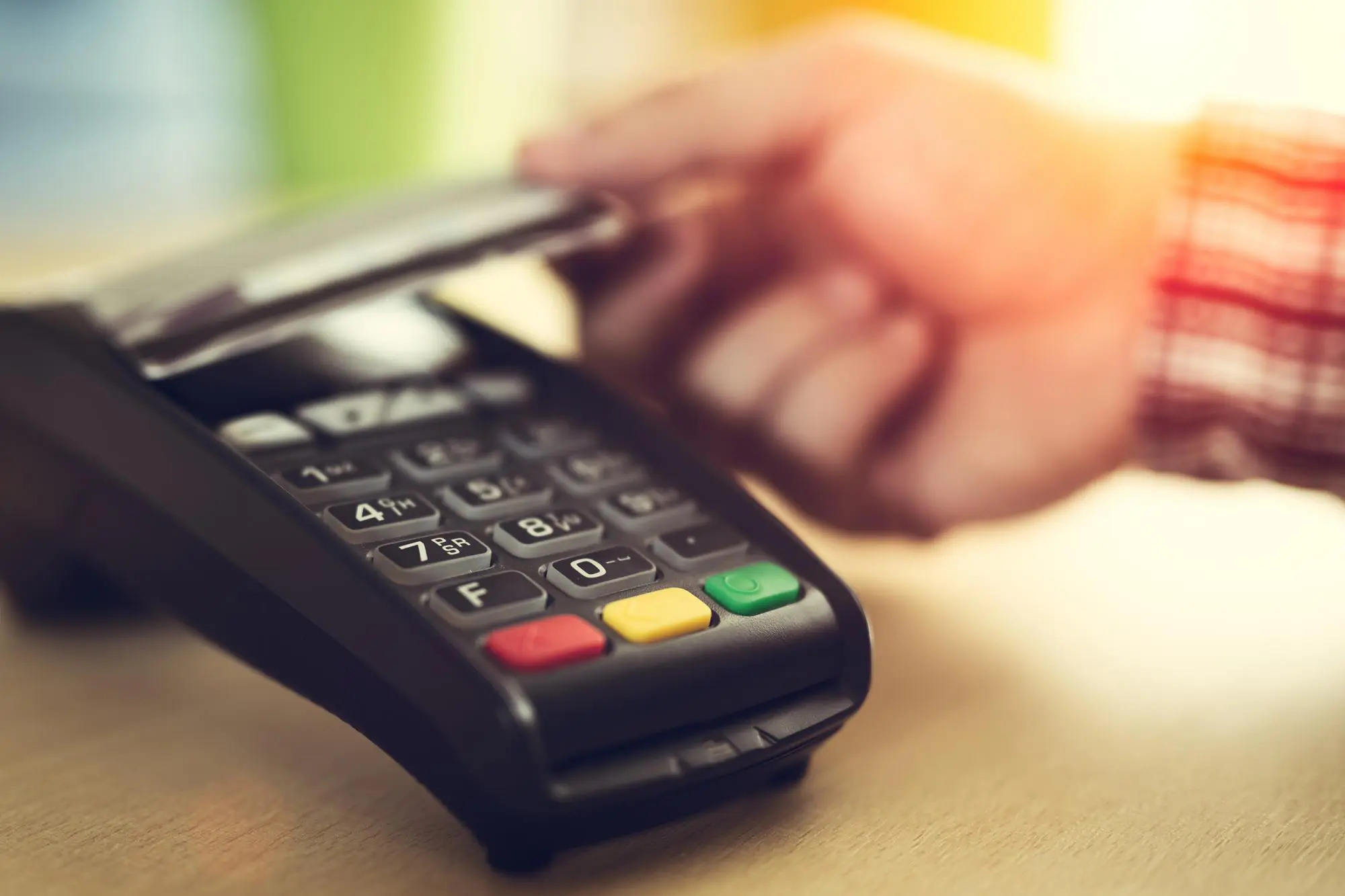 person tapping their credit card on a credit card reader