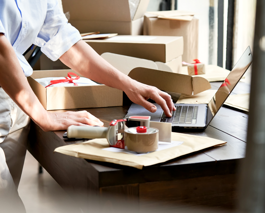 Man works on something with a laptop surrounded by boxes and tapes